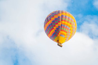Türkiye 'nin Kapadokya kentinin üzerindeki bulutlu mavi gökyüzü arka planında uçan renkli sıcak hava balonu. Seyahat sırasında ekstrem sporlar ve deneyimler. Yüksek kalite fotoğraf