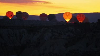 Sabahın erken saatlerinde Türkiye 'nin Kapadokya kentinde uçan dev renkli hava balonlarının manzaralı görüntüleri. Dünyanın en turistik etkinliklerinden biri. Yüksek kalite 4k görüntü
