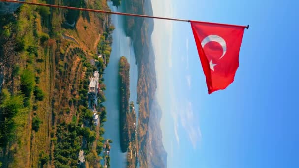 トルコだ トルコの国旗が高い場所から飛んでくる垂直ビデオ 背景の湖 高品質4K映像 — ストック動画