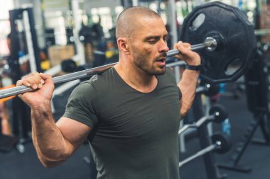 Güç ve kararlılık. Orta sınıf, orta yaşlı, beyaz tenli erkek, vücut geliştirme halterini kaldırırken çekilmiş bir fotoğraf. Yüksek kalite fotoğraf