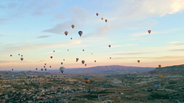 カッパドキア岩の風景の上を飛ぶカラフルな気球の多くの上昇ビデオ 高品質4K映像 — ストック動画