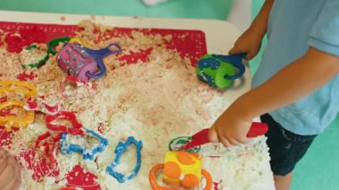 Kumdan büyük ve özel bir şey yapmak istiyorum. Çocuklar kreşteki kinetik kumun tadını çıkarıyorlar. Yüksek kalite 4k görüntü