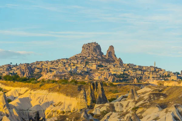 土耳其卡帕多西亚的岩石山上雕刻的建筑物 落基山脉和草原 蓝天清澈 夏日清晨阳光灿烂 旅游目的地 侧向射击 高质量的 — 图库照片
