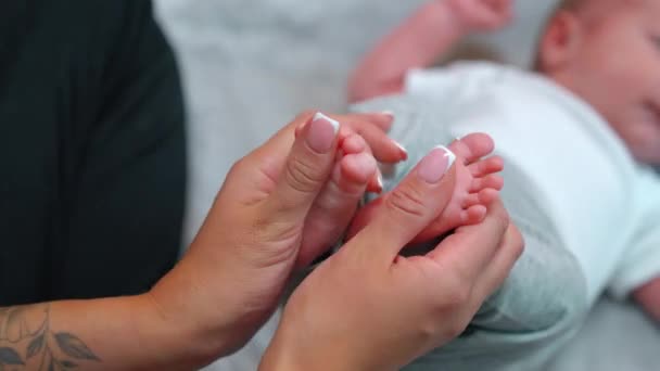 大人と幼児のサイズの違い よく維持された爪を持つ認識できない入れ墨の親は 足のマッサージとくすぐるようなぼやけた幼児の男の子を与えます 高品質4K映像 — ストック動画