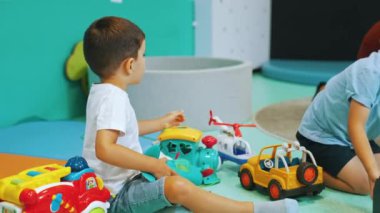 Çocuk odasında arabalarla, trenlerle ve uçaklarla oynayan küçük çocuklar, eğlence zamanı. Yüksek kalite 4k görüntü