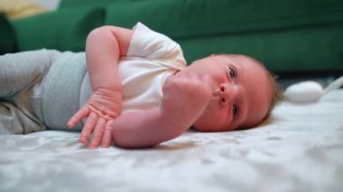 Bebek hayatındaki uykunun önemi. Yorgun beyaz bebek yan yatmış uykuya dalmak için mükemmel bir pozisyon bulmaya çalışıyor. Yüksek kalite 4k görüntü