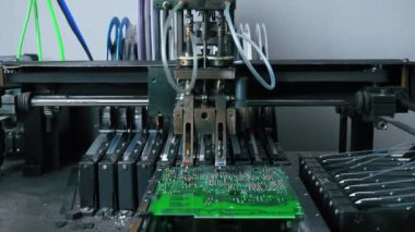 İş sırasında teknolojik olarak gelişmiş SMD montaj makinesi. Robotlar ve teknoloji. Çalışma ortamındaki makineler. PCB tahtası. Yüksek kalite 4k görüntü