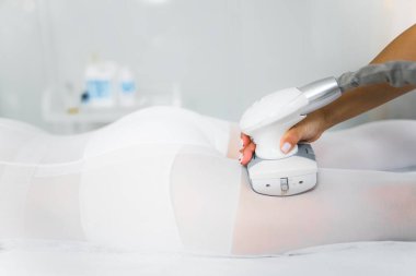 Asyalı bir bayan müşterinin kalçasında karın üstü uzanan lipomasaj tekniği uygulandı. Profesyonel endermoloji LPG makinesi. Yüksek kalite fotoğraf