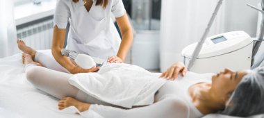 Profesyonel SPA ve Sağlık Merkezi 'nde endermoloji lipomasaj tekniği prosedürü sırasında koruyucu giysili genç bir Asyalı hastanın kapalı çekimleri. Yüksek kalite fotoğraf