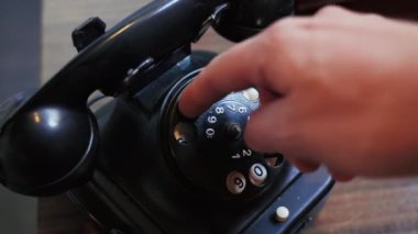 Bir el, sanki arama yapıyormuş gibi eski siyah bir telefonu çevirir. Yüksek kalite 4k görüntü