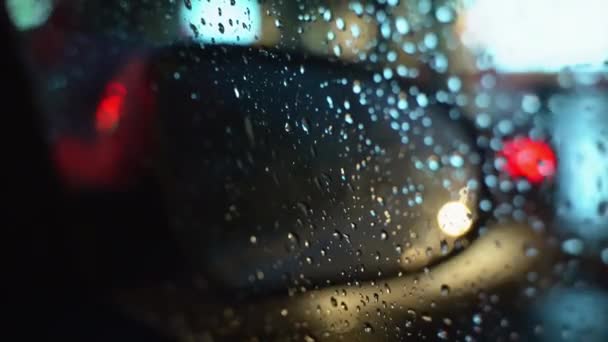 在晚上用非常规的方式展示汽车的侧视镜 透过布满雨滴的透明玻璃窗观看 慢动作高质量的4K镜头 — 图库视频影像