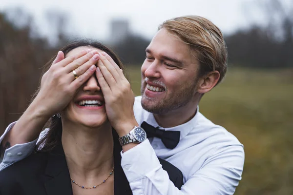妻の目を手で覆っている男 結婚式の日に若い遊び心のあるカップル 高品質の写真 — ストック写真