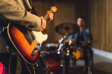 Bir davulcuyla elektro gitar çalan adama yakın çekim. Yüksek kalite fotoğraf