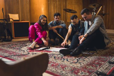 Müzik grubu üyeleri yerde notalarla prova yapıyorlar. Yüksek kalite fotoğraf