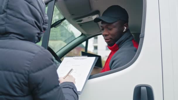 Jonge Volwassen Zwarte Bezorger Zittend Een Witte Bestelwagen Leunend Uit — Stockvideo