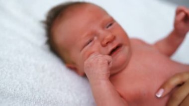 Bebek bezi değiştirirken yumuşak beyaz battaniyeye uzanmış beyaz tenli yeni doğmuş beyaz erkek bebek. Yakın plan çekim. Yüksek kalite 4k görüntü