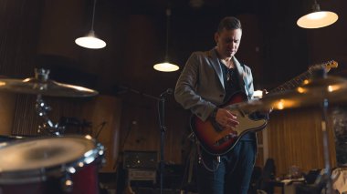 Stüdyoda müzik aletleri ve ekipmanlarıyla elektro gitar çalan bir adam. Yüksek kalite fotoğraf