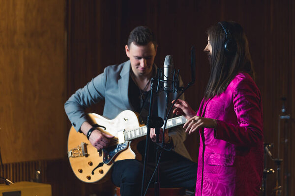 Woman singing and the man accompanying her on the electric guitar . High quality photo