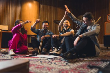 Müzik grubu yerde oturuyor. Prova. Yüksek kalite fotoğraf