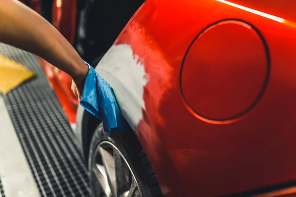 无法辨认的高加索机修工的手 用蓝色的布在涂漆前把红色汽车的表面磨平 高质量的照片 — 图库照片