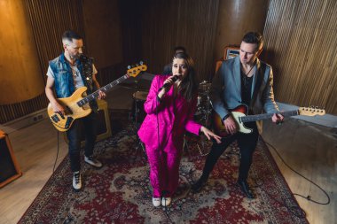 Stüdyoda müzik grubu çalıyor, yerde eski bir halı var. Yüksek açılı görüş. Yüksek kalite fotoğraf