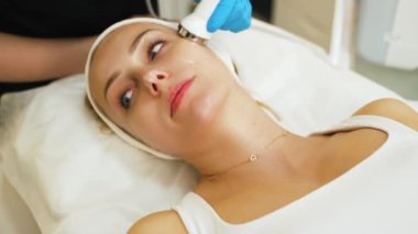 SPA tedavi günü. Profesyonel tanınmayan kozmetikçiler tarafından yapılan mikro dermabrüksiyon işlemi sırasında yalancı beyaz bir kadının kapalı mekan portresi. Yüksek kalite 4k görüntü