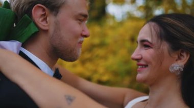 Sonbahar ormanının inanılmaz renkleri. Düğün fotoğrafı çekilirken heteroseksüel bir çift. Kafkasyalı eş ve Türk karısının evlilik kıyafetleri içinde yan yana durduğu orta boy bir fotoğraf. Yüksek kalite