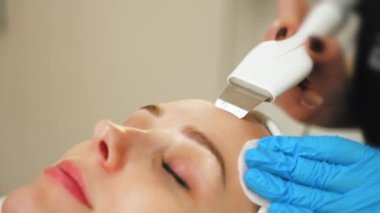 Tüm deri tipleri için acısız SPA tedavisi - mikro cilt bakımı. Güzel beyaz hastasının cildinde mikro dermabrüksiyon aletleri kullanarak güzellik uzmanının aşırı yakın plan portresi. Yüksek kalite 4k