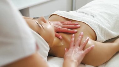 Genç, güzel bir Asyalı kadın estetik bir salonda profesyonel boyun masajı yaptırıyor. Tanımlanamayan beyaz güzellik uzmanı kadın müşterisine masaj yapıyor. Yüksek kalite 4k görüntü