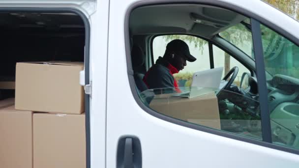 Siyah Yetişkin Bir Teslimatçı Elinde Karton Kutularla Beyaz Minibüste Oturuyor — Stok video
