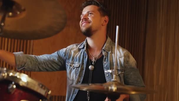 若い男性ミュージシャンがスタジオでドラムを演奏している 高品質4K映像 — ストック動画