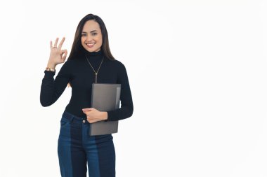 Balıkçı yaka ve kot pantolon giyen Latin Amerikalı genç bir kadın elinde belge dosyasıyla kameraya gülümseyen mükemmel bir jest yapıyor. Yatay beyaz arka plan fotokopi stüdyosu. Yüksek kalite