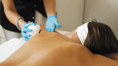 Bir kadın masaya uzanıyor ve güzellik prosedürlerini uyguluyor. Yüksek kalite 4k görüntü