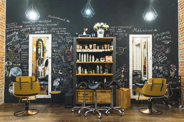 Modern hair salon interior. Amazing design of haircut area with big mirror and comfortable chairs. High quality photo