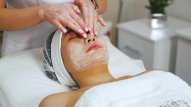 Kozmetoloji merkezindeki güzel bir Asyalı kız ve onun için yüz ameliyatı yapan bir spesiyalist, cilt bakımı konsepti. Yüksek kalite 4k görüntü