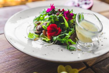 Restoran yemeği. Lezzetli ördek salatası, yenilebilir çiçekler ve geleneksel Polonya peyniri ile servis edilir. Güzel yemek konsepti. Yüksek kalite fotoğraf