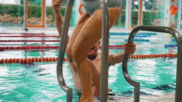 Yaşlı Adam Karısının Merdivenin Yanındaki Havuza Inmesine Yardım Ediyor Yüksek — Stok video