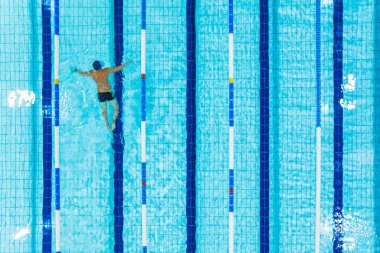 Havuz şeridinde yüzen bir adamın üst hava görüntüsü. Yüksek kalite fotoğraf