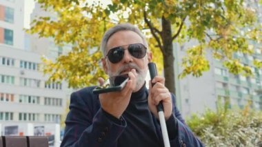 Parkta hoparlörden konuşan zarif, kör sakallı adam. Yüksek kalite 4k görüntü