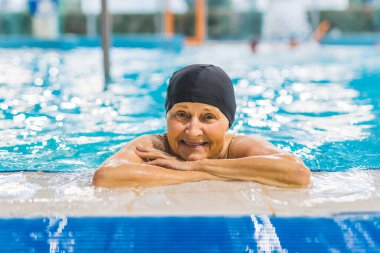 Yüzme havuzunda siyah yüzme şapkası takan mutlu bir son sınıf öğrencisi. Yüksek kalite fotoğraf