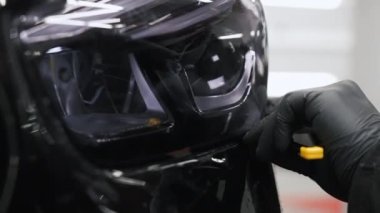 Profesyonel bir araba lambası boyasının yakın çekimi. Uzman bıçak kullanıyormuş. Son derece yakın çekim. Yüksek kalite 4k görüntü