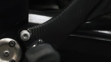 Motosikletin siyah kısımlarına yakın çekim. Yakından yukarı doğru yavaşça hareket ediyor. Yüksek kalite 4k görüntü