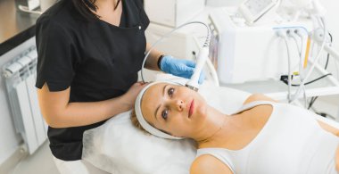 Bir kadının yüksek açılı görüntüsü, gözleri açık uzanmış ve mikro dermabrüksiyon tedavisi gördüğü. Güzellik konsepti. Yüksek kalite fotoğraf