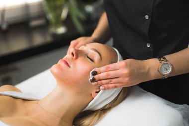 Bir kadının yüzünün pamuk yastıkla temizlenmiş olduğu yakın plan bir fotoğraf. Güzellik konsepti. Yüksek kalite fotoğraf