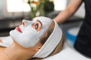 Gözleri açık ve cilt bakım maskesi takmış bir kadının yakın çekimi. Güzellik konsepti. Yüksek kalite fotoğraf