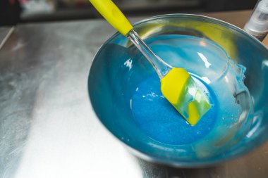 Paslanmaz çelikten bir kasede spatulayla birlikte mavi krema. Aşçılık ve fırın konsepti. Yüksek açı. Yüksek kalite fotoğraf