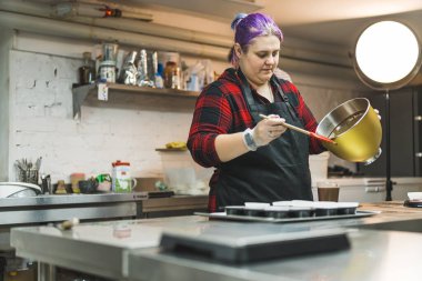 Pastaneci - Şeker hazırlayan pastacı. Beyaz adam spatula kullanıyor ve profesyonel fırın mutfağında bowling oynuyor. Yüksek kalite fotoğraf