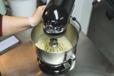 Kullanımda olan bir gıda işlemcisinin yakın plan portresi. Vanilyalı krema karışımı karıştırıyorum. Yüksek açı. Yüksek kalite fotoğraf