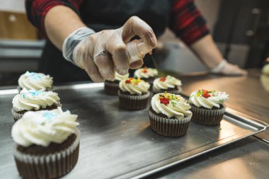 process of decorating cupcakes for New Year or Christmas dinner at the bakery, festive concept. High quality photo