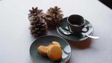 a cup of tea, baked cookies and pine cones on the table, closeup view New Year and winter concept. High quality 4k footage